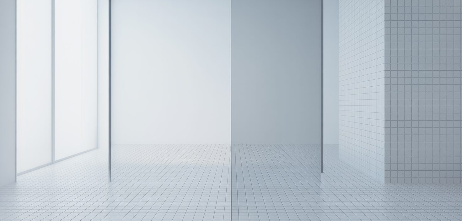 Ett rent och minimalistiskt badrum, med en strålande vit kakelvägg och en reflekterande spegel.